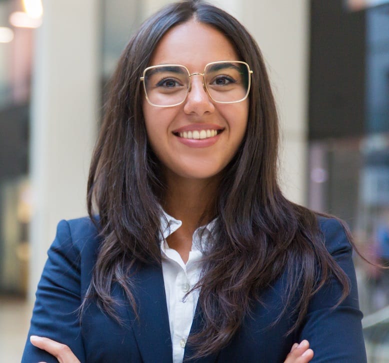 Young businesswoman smiling at camera. Portrait of cheerful Hispanic businesswoman in formal wear standing with crossed arms and looking at camera. Business concept
